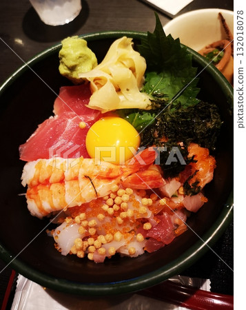 Bowl of rice topped with sashimi  132018078
