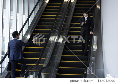 Businessman riding escalator 132018090