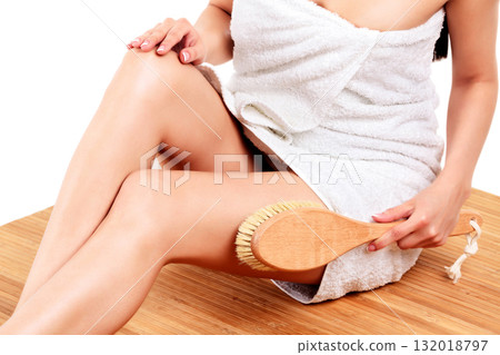 Woman is massaging skin on her legs with big brush, isolated on white background Woman is massaging skin on her legs with big brush, isolated on white background 132018797