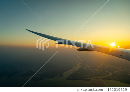 Airplane wing above Osaka coast during sunset descent flight Airplane wing above Osaka coast during sunset descent flight 132019819