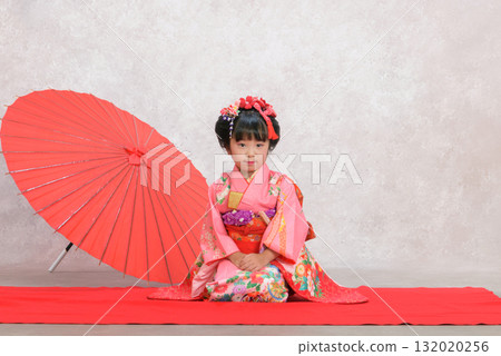 A girl in a kimono sitting upright 132020256
