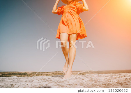 Woman in Orange Dress Walking on a Cliff 132020632