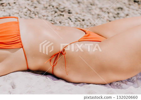 Woman Bikini Beach Sunbathing - Close-up of a woman in a bikini sunbathing on a beach. Woman Bikini Beach Sunbathing - Close-up of a woman in a bikini sunbathing on a beach. 132020660