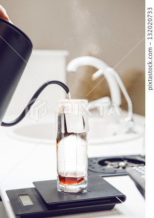 Brewing Coffee With a Drip Bag in a Glass, Showcasing Precise Measurements in a Modern Kitchen Setting Brewing Coffee With a Drip Bag in a Glass, Showcasing Precise Measurements in a Modern Kitchen Setting 132020733