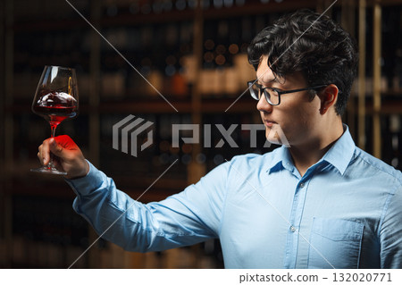 Professional Sommelier Examining Red Wine Clarity of Color in Cellar Professional Sommelier Examining Red Wine Clarity of Color in Cellar 132020771