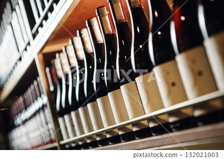Elite Wine Bottles Lined Up on Shelf in Close-Up View, Focus on Foreground 132021003