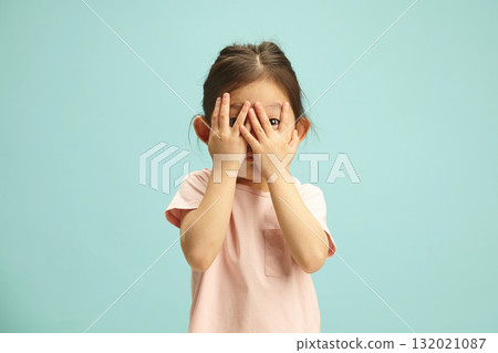 Scared Little Kid Covering Face with Hands From Afraid During Parents Family Scandal stand over blue isolated. 132021087