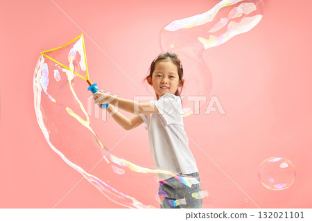 Funny Little Asian Girl Making Big Soap Bubbles on Pink Isolated Funny Little Asian Girl Making Big Soap Bubbles on Pink Isolated 132021101