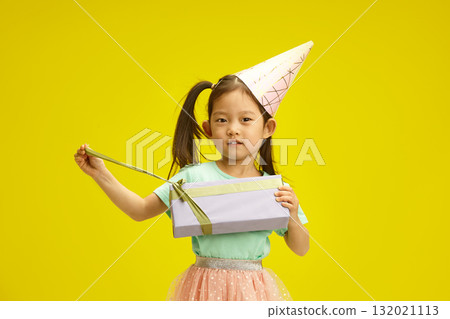 Lovely Chinese Child Girl Opening Birthday Box Gift Standing on Yellow Backdrop Lovely Chinese Child Girl Opening Birthday Box Gift Standing on Yellow Backdrop 132021113