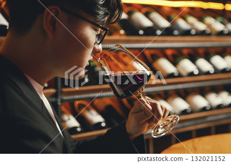 Man Smelling Red Wine in Cellar Atmosphere Man Smelling Red Wine in Cellar Atmosphere 132021152