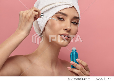Asian girl in white hair turban using serum, retinol. Asian girl in white hair turban using serum, retinol. 132021232