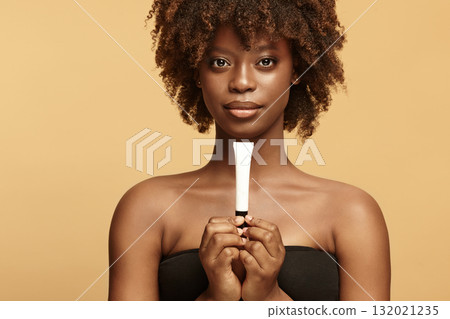 African American woman keeps small white tube mockup. 132021235