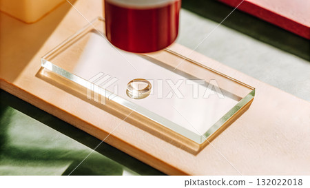 Luminous gold ring being examined through a magnifying glass at a craft studio 132022018