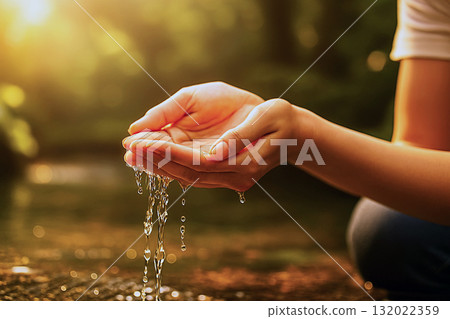 A woman scooping spring water with her hands 132022359