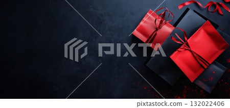 Luxurious red and black gift boxes with ribbons on a dark background, perfect for holiday or special occasion presentations. Copy space available 132022406