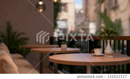 A coffee cup on round stool table with fabric sofa on the cafe terrace or balcony. 132022527