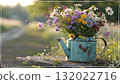 Rustic Flower Vase in Sunlit Garden.Turquoise watering can with wildflowers on grass, glowing in warm sunlight. Perfect for spring, nature, and romantic themes. 132022716