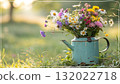 Rustic Flower Vase in Sunlit Garden.Turquoise watering can with wildflowers on grass, glowing in warm sunlight. Perfect for spring, nature, and romantic themes. 132022718