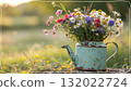Rustic Flower Vase in Sunlit Garden.Turquoise watering can with wildflowers on grass, glowing in warm sunlight. Perfect for spring, nature, and romantic themes. 132022724