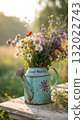 Rustic Flower Vase in Sunlit Garden.Turquoise watering can with wildflowers on grass, glowing in warm sunlight. Perfect for spring, nature, and romantic themes. 132022743