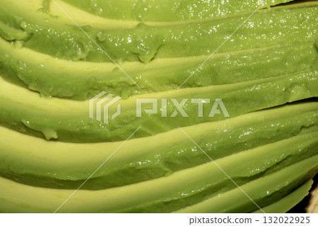 Close up of green fresh avocado sliced on chopping board Close up of green fresh avocado sliced on chopping board 132022925