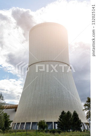 Tall cooling tower releasing steam into blue sky, symbol industrial energy production and technology. The structure represents power generation, heat emission and environmental engineering in Germany Tall cooling tower releasing steam into blue sky, symbol industrial energy production and technology. The structure represents power generation, heat emission and environmental engineering in Germany 132025141