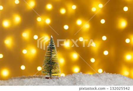 Christmas tree in snow with gifts on glowing lights bokeh background 132025542