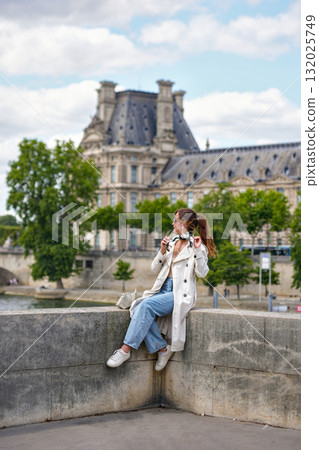 Woman near Louvre Museum and Pont Royal bridge in Paris 132025749