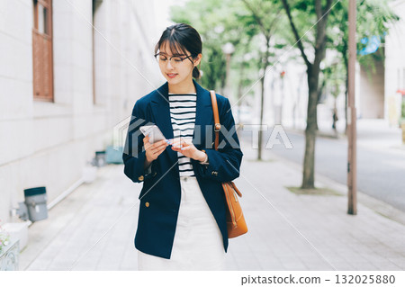 Young woman looking at smartphone in the city 132025880