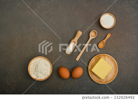 Basic baking ingredients arranged on dark background creating copy space Basic baking ingredients arranged on dark background creating copy space 132026492