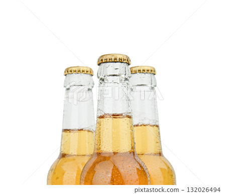 Three beer bottles with condensation and golden caps on white background 132026494