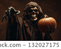 Grim reaper holding pumpkin in the dark 132027175