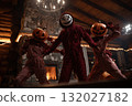 Friends wearing scary costumes dancing in halloween party in a wooden house 132027182
