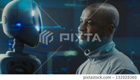 Guy Smiling Warmly While Looking Futuristic Robot With AI and Shiny Details Guy Smiling Warmly While Looking Futuristic Robot With AI and Shiny Details 132028360