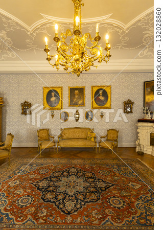 Golden chandelier illuminating antique European castle interior 132028860