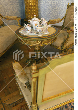 Ornate antique tea set on elegant side table 132028862