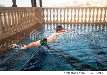Child Diving Into Clear Pool Water With Joy And Enthusiasm 132028992