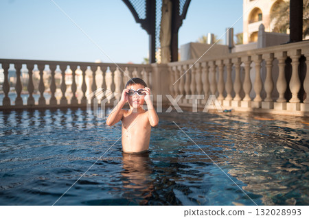 Boy With Swimming Goggles Enjoying The Pool On A Sunny Day Outdoors 132028993