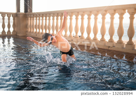 Child Diving Into Clear Pool Water With Joy And Enthusiasm 132028994