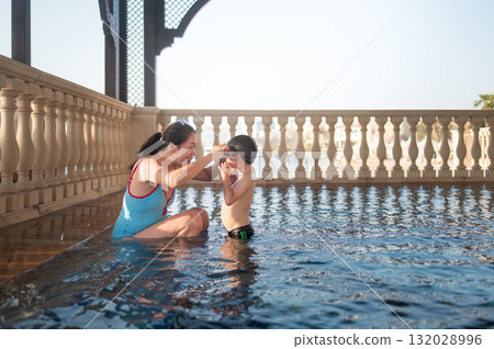 Joyful Moments: Child Playfully Having Fun In Pool With His Mom Joyful Moments: Child Playfully Having Fun In Pool With His Mom 132028996