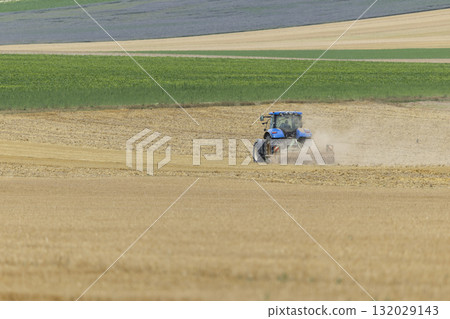 Blue tractor plowing dry stubble field in D40, Etrechy 132029143