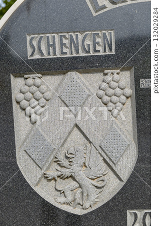 Schengen coat of arms carved on stone monument 132029284