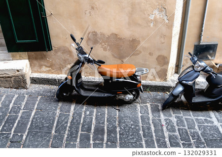 Two scooters parked by the wall on a narrow street in Sicily, Italy Two scooters parked by the wall on a narrow street in Sicily, Italy 132029331