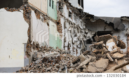 Demolition of a building in progress with rubble scattered on the ground at the construction site 132030184