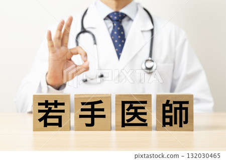 A block with the words "Young Doctor" written on it and a doctor making an OK sign 132030465
