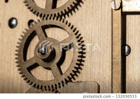 A detailed close-up of bronze gears meshing inside a clock mechanism 132030553
