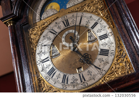 A detailed shot of a vintage grandfather clock featuring a brass center, A detailed shot of a vintage grandfather clock featuring a brass center, 132030556