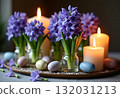 Beautiful elegant table setting for Easter celebration with fresh spring hyacinth flowers, burning candles. Romantic wedding dinner table decoration. Springtime, home gardening. Dark background 132031213