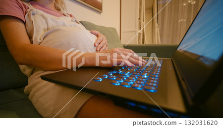 Pregnant woman typing on keyboard of laptop. Pregnant woman typing on keyboard of laptop. 132031620
