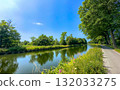 Enjoy a Serene Canal View on a Beautiful Sunny Day, Surrounded by Lush Greenery and Nature 132033275